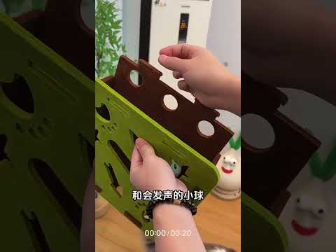 Real cat playing with felt puzzle maze box and jingle bell balls